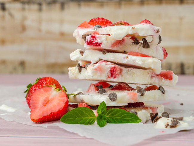堆栈的冷冻酸奶树皮在每一块草莓和巧克力。