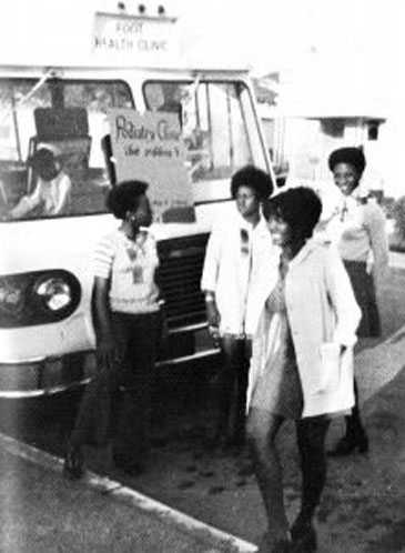 20世纪70年代的黑白照片，4名凯撒黑人学生护士协会的成员站在一辆移动医疗车前