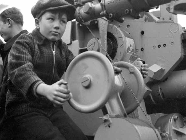 一个拿着5英寸甲板炮的孩子，可能是在1943年海军参观日的潜艇上