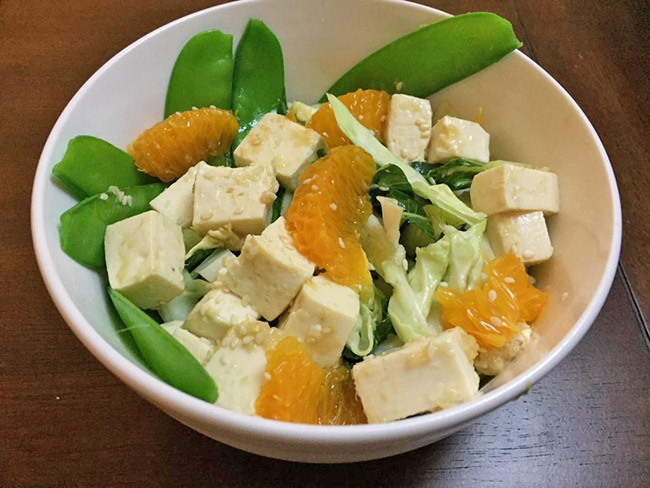一碗豆腐沙拉的卷心菜、豌豆和橘子。